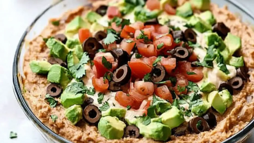 a taco dip in a glass dish with the text dairy free taco dip
