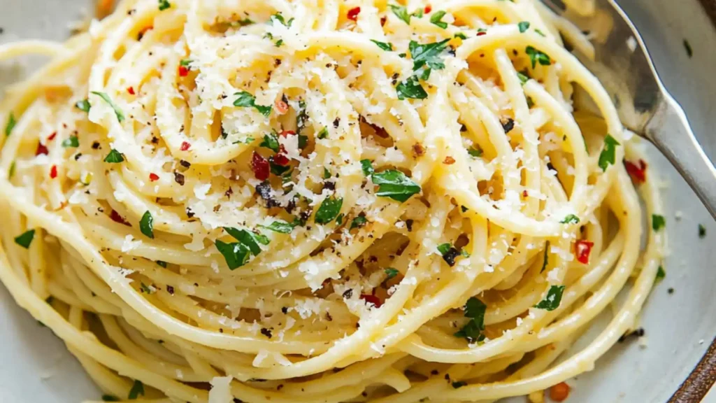 a white plate topped with pasta and parmesan cheese