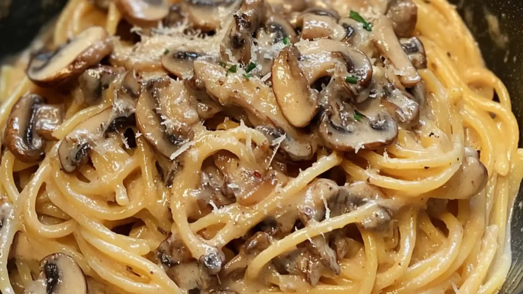 a pan filled with pasta and spinach on top of a table next to cheese