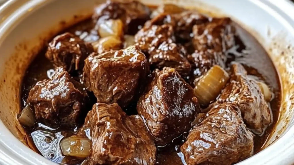slow cooker beef tips on top of mashed potatoes