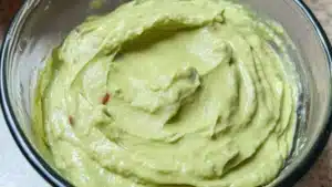 avocado dip in a bowl with the words creamy avocado dip above it