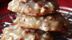 no bake coconut pecan pralie cookies on a black plate with yellow and white towel