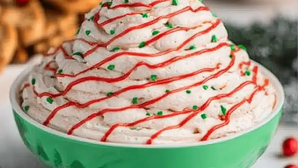 a christmas tree cake dip with white frosting and sprinkles on top