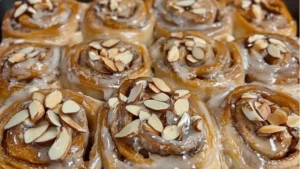 an almond sweet roll is shown in a white dish with the words gooey on it