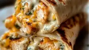 chicken wraps with cheese on top and the words, gooey - gooey cheesy garlic chicken wraps