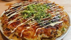 plates with food and chopsticks sitting on a marble counter top next to the words okonomiyaki savory japanese pancake