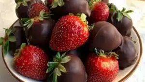 a white bowl filled with chocolate covered strawberries