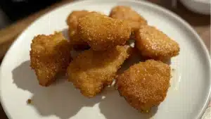 some fried food is on a blue plate and the words mcdonald's copycat mcnuggets are above it