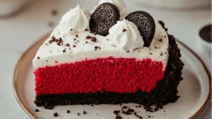 a slice of christmas red velvet cheesecake with oreo crust on a white plate
