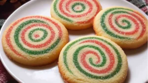 red, white and green cookies with sprinkles stacked on top of each other