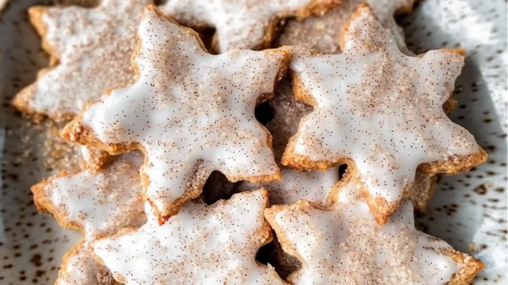 cinnamon stars are stacked on top of each other with icing and nuts in the background