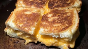 Baking dish of golden Hawaiian rolls stuffed with melted cheese