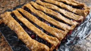 a close up of a pie on a table with strawberries and other food items