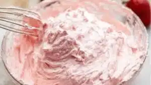 Close up image of swirled strawberry cream cheese frosting with text cutting through the center reading "fresh strawberry cream cheese frosting"