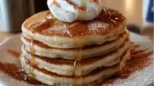 pancakes stacked on top of each other with butter and syrup