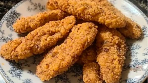 chicken tenders on a white plate with sauce and parsley in the background text overlay reads easy and quick crock chicken tenders