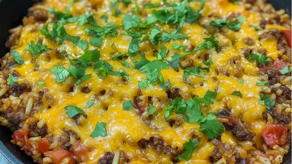 a skillet filled with taco rice and an avocado on the side